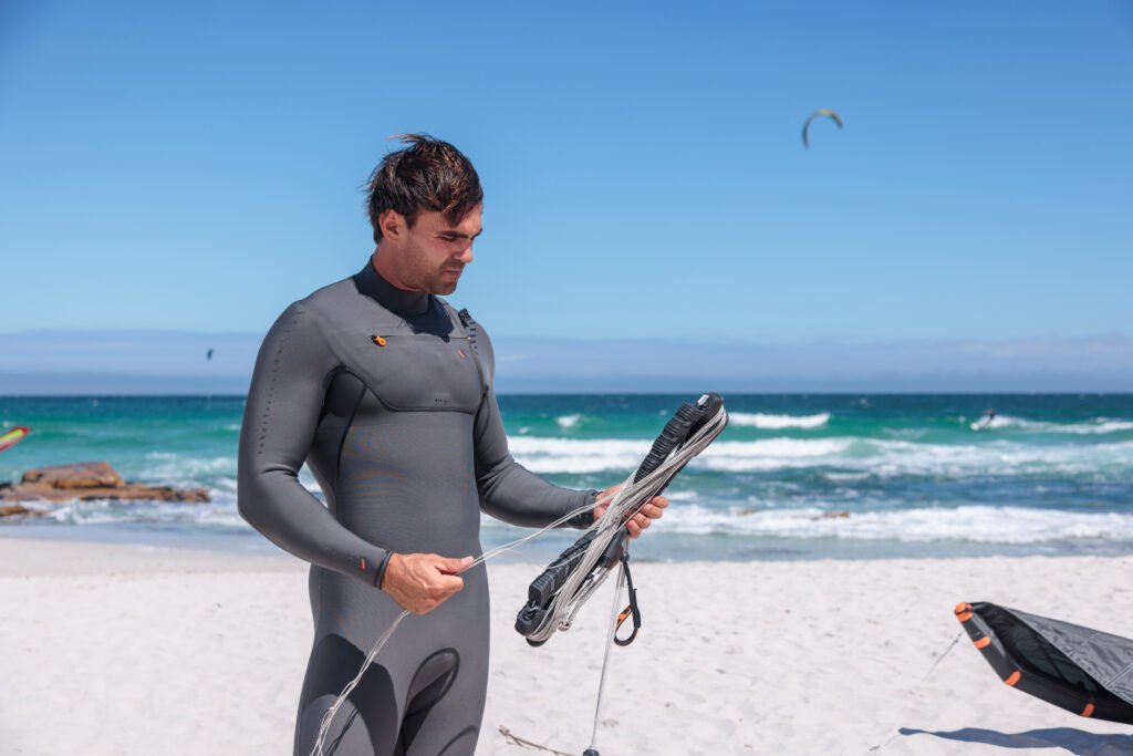 Kite surfista sulla spiaggia di Fiumara, mentre prepara l'attrezzatura per una sessione di kite surfing.